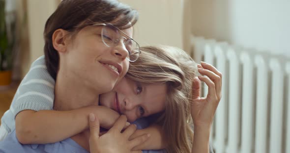 Close Up Portrait of Pretty Smiling Child Daughter Embrace Mom. Happy Beautiful Family Young Adult