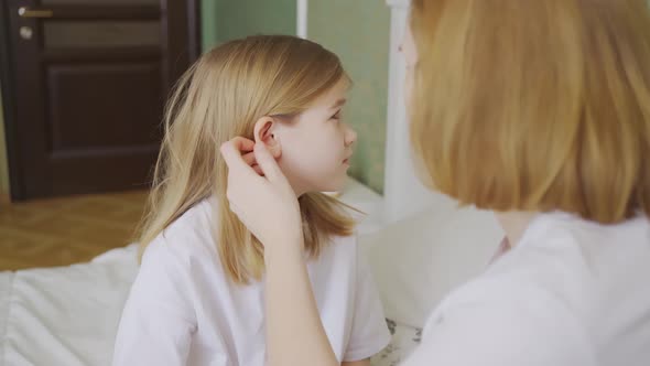 Daughter Complains About Pain in the Ear and Mother Examines Her