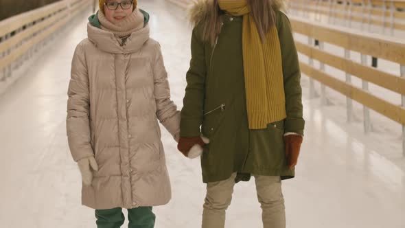 Mom And Daughter On Ice Rink