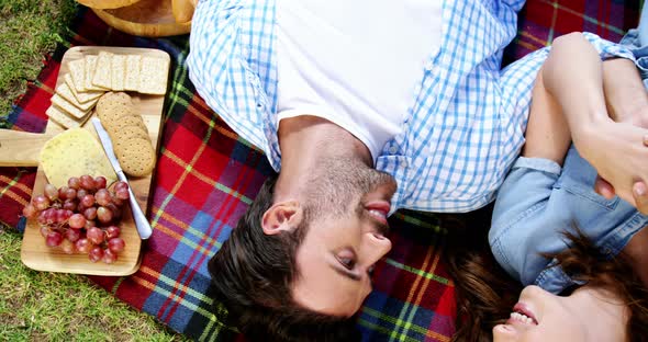 Couple lying on picnic blanket