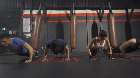 Group of people doing body push up in boxing sport club workout at training gym fitness center