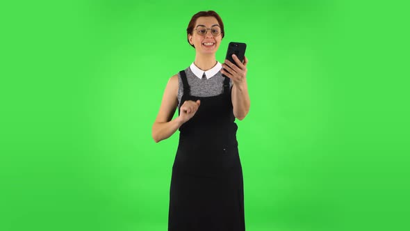 Funny Girl in Round Glasses Is Talking for Video Chat Using Mobile Phone and Rejoicing, Green Screen