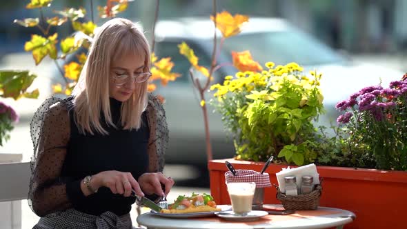 Blonde Woman Is Enjoying Italian Cuisine in Street Cafe, Sitting at Outdoor Terrace at Sunny Autumn