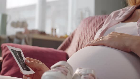 Expectant Mother Looking at Sonogram Image and Smiling