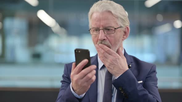 Portrait of Old Businessman Loss on Smartphone