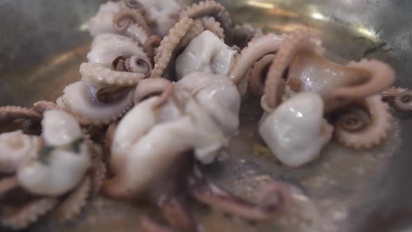Octopuses Fry in Boiling Oil on Metal Frying Pan in Kitchen
