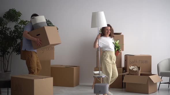 Happy Married Couple Takes Out the Packed Things From the Apartment and Dancing