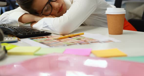 Female graphic designer sleeping at desk