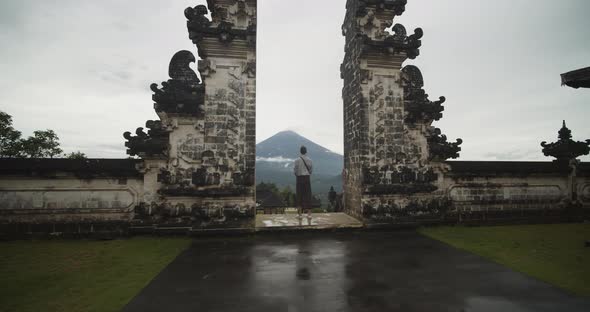 Dolly Wide Shot Closing in on a Man Standing Between the Gates of Heaven in Pura Penataran Agung