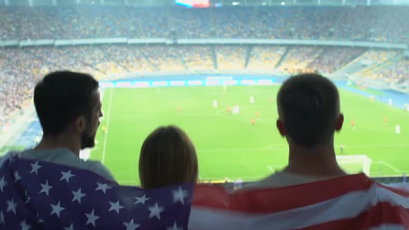 American Football Fans Supporting Team During Soccer Match on Crowded Stadium