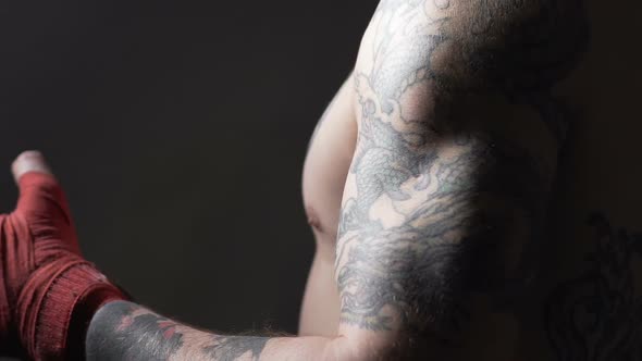 Muscular Muay Thai Boxer With Tattoos Pulling Bandage on His Hand, Slowmotion