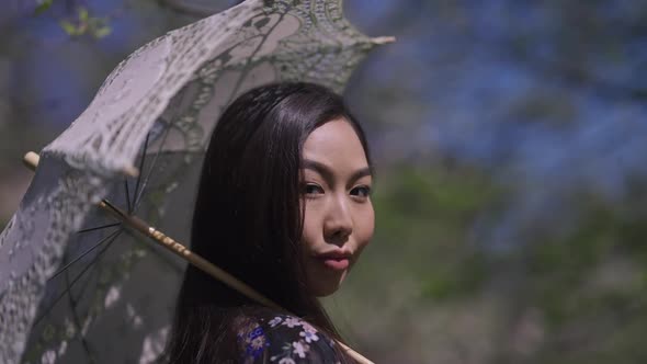 Closeup White Sun Umbrella Turning and Young Beautiful Asian Woman Looking at Camera Smiling