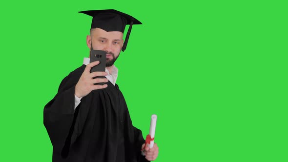 Man Wearing the Graduation Robe Walking and Taking Selfie with Diploma on a Green Screen, Chroma Key