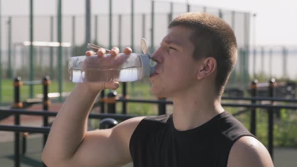 Athletic Man Drinking Water During Outdoor Workout