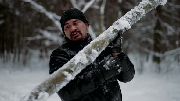 Strong Man is Lifting Log in Winter Forest Training Alone in Nature Keeping Fit