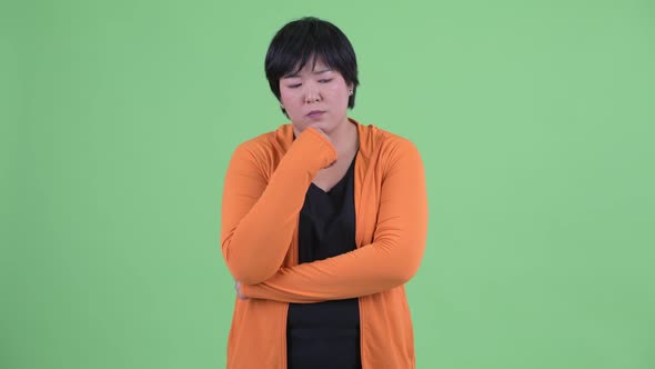 Stressed Young Overweight Asian Woman Thinking and Looking Down