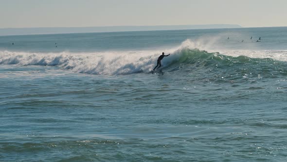 Surfer catching blue waves of the Atlantic Ocean on a beautiful sunny day