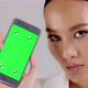 Beautiful Asian businesswoman showing smartphone with green screen - VideoHive Item for Sale