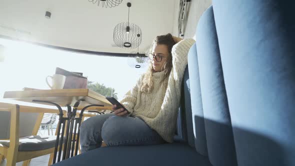 Woman in Loose Sweater Relax in Cafe
