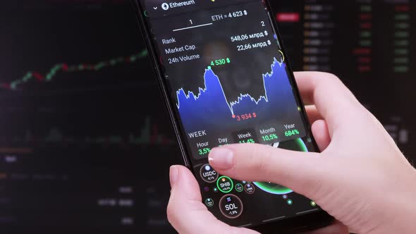 Broker touches screen with a finger, analyzes financial indicators SOL, ETH