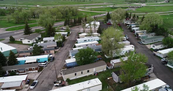 A poor neighborhood with mobile homes next to the highway.