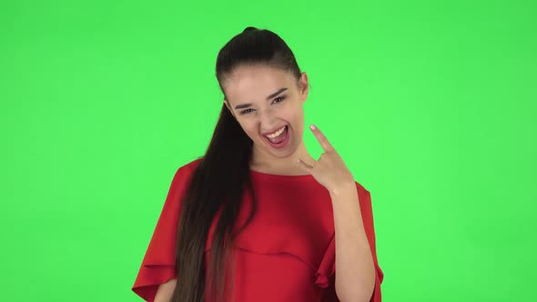 Portrait of Pretty Young Woman Is Making a Rock Gesture and Enjoying Life