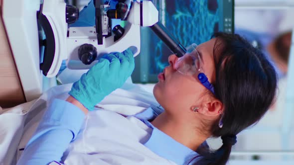 Vertical Video Scientist Woman with Microscope Examining Samples and Liquid