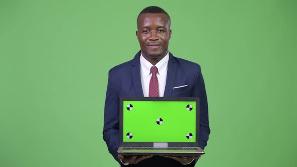 Young Happy African Businessman Showing Laptop