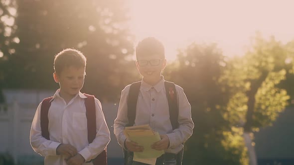 Schoolboy in Glasses Throws Papers Walking with Friend Slow