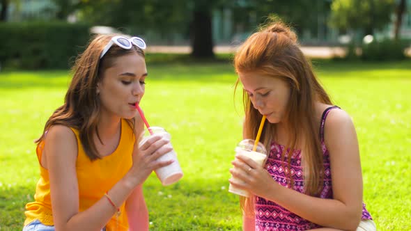 Teenage Girls Drink Milk Shakes at Picnic in Park