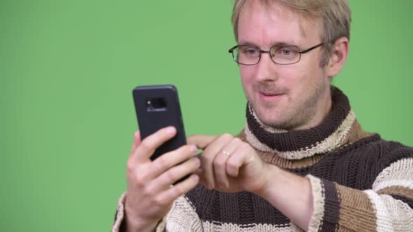 Studio Shot of Happy Handsome Man Using Phone and Getting Good News