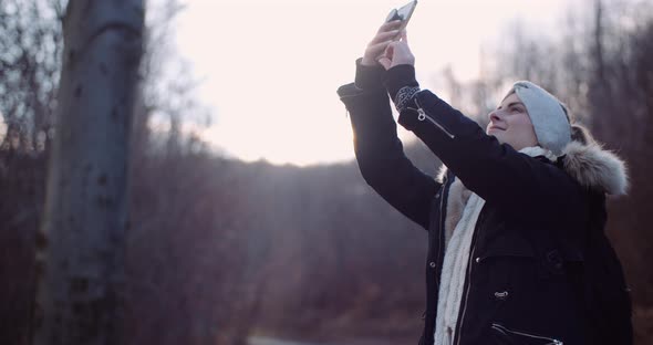 Technology - Woman Using Smartphone To Take Picture in Autumn