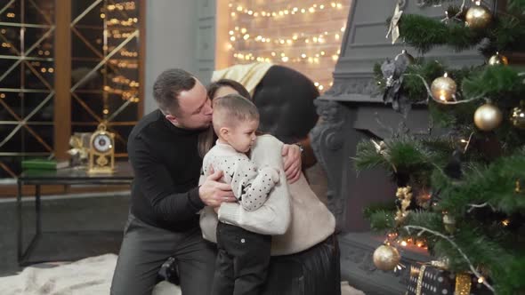 Cute family is preparing a christmas tree in their home before New Year. Young mother, father and th