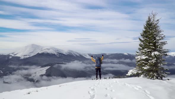 A Man with a Backpack Travels in the Mountains in Winter