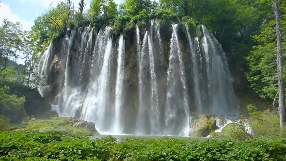 Wide angle view of a beautiful waterfall showering down into a lake in Plitvice Lakes National Park