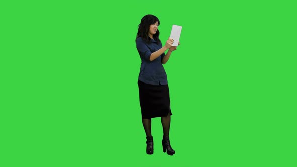 Asian Lady Having Video Chat Using a Tablet on a Green Screen, Chroma Key