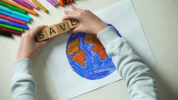 Child Putting Save Word and Heart Sign on Planet Painting