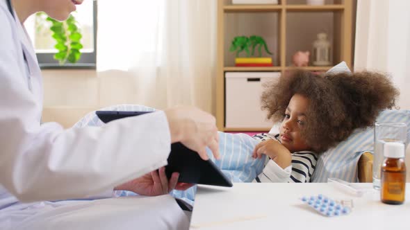 Doctor with Tablet Computer and Sick Girl in Bed