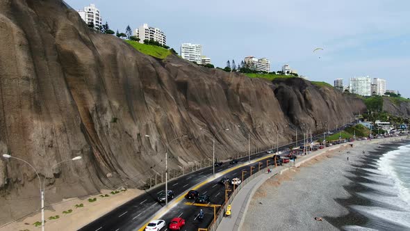 Boom job down 4k aerial video of the Miraflores coast in Lima, Peru, in a summer sunny day. People a