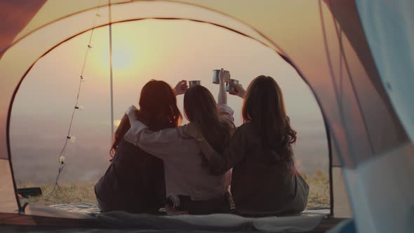 Asian young women drinking coffee in a tent.
