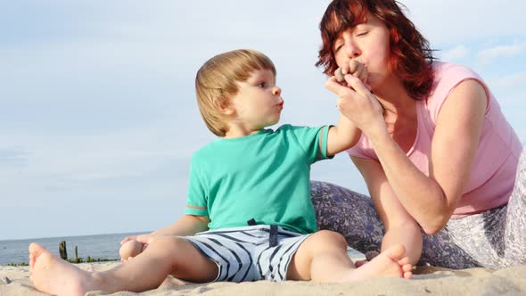 Mother Plays With Little Child On Beach