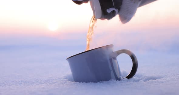 Pouring Tea From a Thermos Into a Cup on a Cold Winter Day