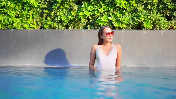 Young asian woman enjoy around outdoor swimming pool for leisure