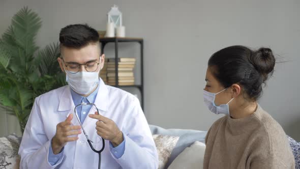 Hospital Ward: Friendly Doctor Uses Stethoscope to Listen to Heartbeat and Lungs of Recovering