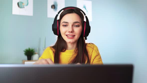 Girl Student in Headphones Learns Laptop Video Calling App