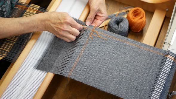 Artisan finishing the weaving project to stop it from unraveling