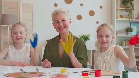 Family Waving Hands Covered in Paint