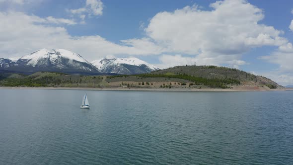 Aerial Flyby Shot of a Lone Sailboat on a Beautiful Mountain Lake in Colorado (Dillon Reservoir)