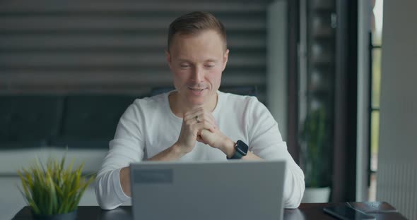 Young Happy Man Talking Via Videoconference on Laptop