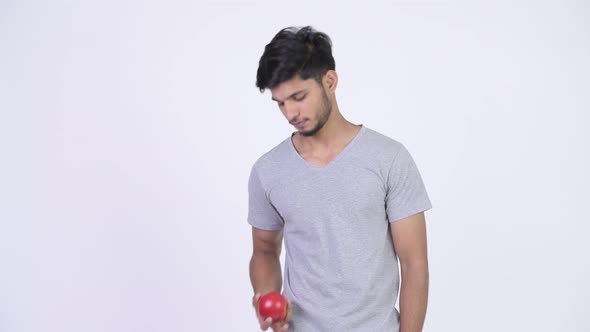 Young Happy Bearded Indian Man Giving Apple